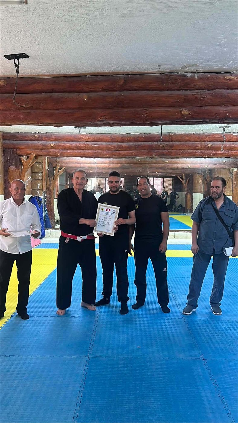 Martial artists and instructors gathered on a training mat during a certification seminar