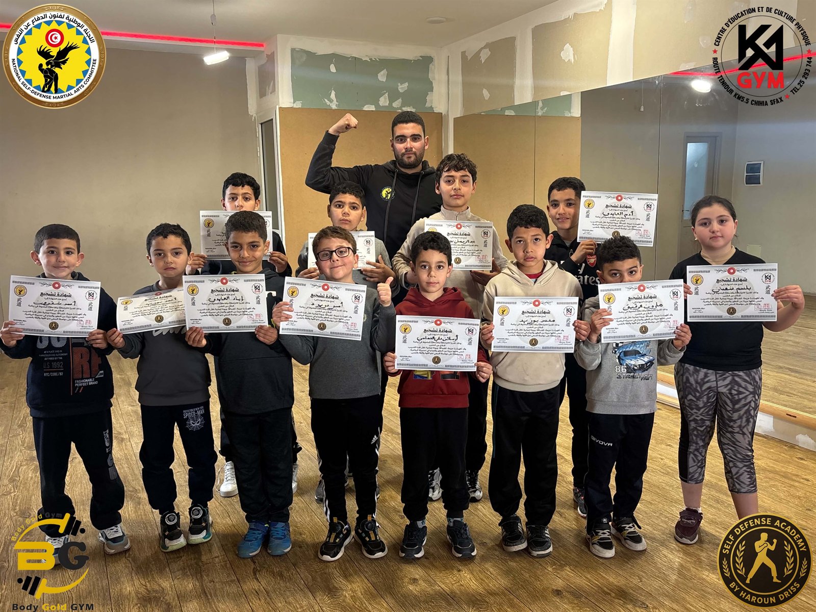 Children holding martial arts certificates after a group achievement ceremony
